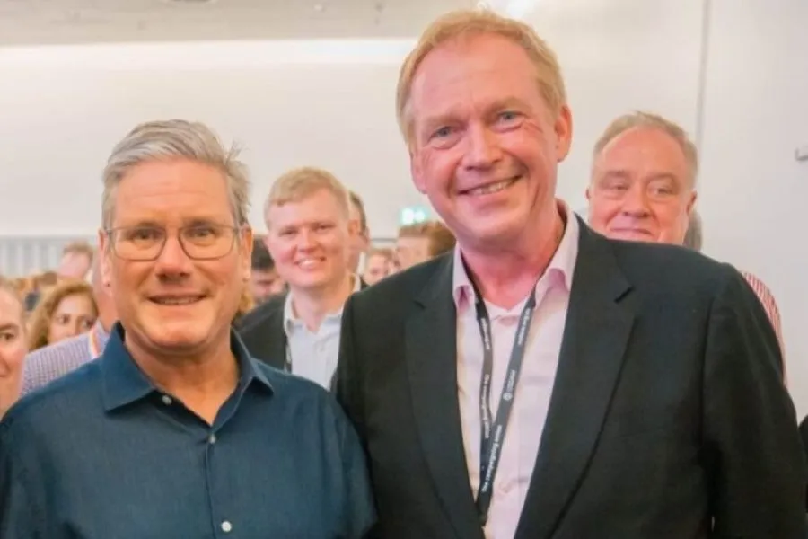 Two men smiling into the camera.